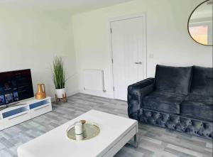 曼彻斯特Stylish New Built的客厅配有黑色沙发和咖啡桌