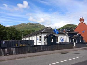 金洛赫利文Coe Pod, West Highland Way Holidays的白色的建筑,上面有一颗蓝色的星