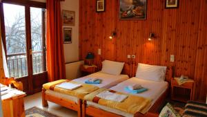 卡兰巴卡索萨斯客房旅馆的配有木墙和窗户的客房内的两张床