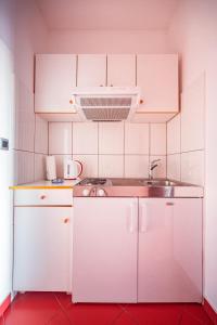 珀德垂那Apartmani Baki的小厨房配有白色橱柜和水槽