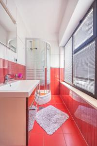 珀德垂那Apartmani Baki的红色的浴室设有水槽和淋浴