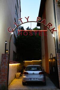 普里什蒂纳City Park Hostel的停在大楼前的带有标志的汽车