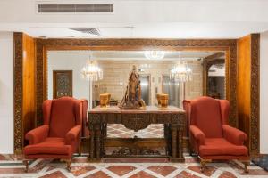 开罗Om Kolthom Hotel的一间带桌子、两把椅子和镜子的用餐室