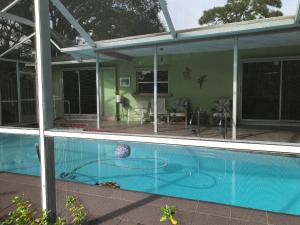 萨拉索塔Casa Limon with HEATED POOL的一座带玻璃窗户的游泳池的房子