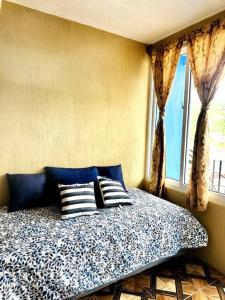 圣佩德罗拉拉古纳Nicolas House #2 with Lake Atitlán View的卧室配有带枕头的床铺和窗户。