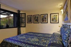 阿索马达Castillo Lanzarote Villa 3 - Sleep in a Volcanic Cave的卧室配有一张床,墙上挂有图片