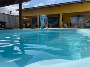 马拉戈日Casa Temporada Suítes的一个带喷泉的游泳池