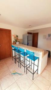 ParaguachiPosada Villa Mayo Apartamento Familiar a 5 Min de Playa Parguito的厨房设有带4张蓝色酒吧凳的酒吧