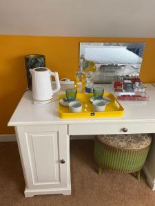 马拉海德ByTheSea的一张白色的桌子,上面有黄色的盘子