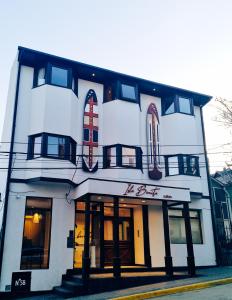 乌斯怀亚Isla Bonita Suites的一间大型白色建筑,前面是商店