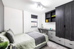 利兹Hot Deal - Luxury Apartment close to Leeds City Centre的一间卧室配有一张床和一个黑色橱柜