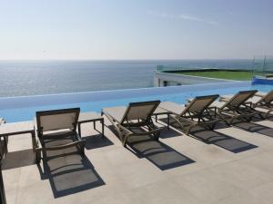 北马马亚-讷沃达里Alee Infinity Pool & Spa by Black Sea的一组椅子和一张桌子