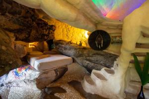 伊加图Pousada Flor de Açucena的洞穴内的一个房间,在岩石墙上设有一张床