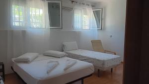马德里El Colmenar Habitaciones的客房设有两张床、椅子和窗户。