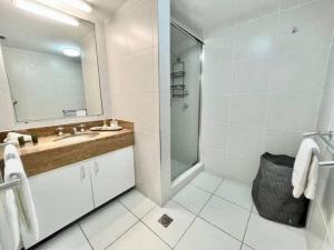 努萨角Paradise plantation on Noosa Hill 143NI的浴室配有盥洗盆和带镜子的淋浴