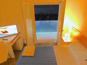 罗迪-加尔加尼科Albergo Lido Diomedee的一间设有一张床的房间和一扇带窗户的门