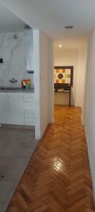 布宜诺斯艾利斯Departamento Pucara Obelisco的厨房铺有木地板,配有白色橱柜。