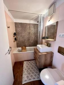 舍讷费尔德BALI HOME Stylische Wohnung mit Terrasse的带浴缸、盥洗盆和卫生间的浴室