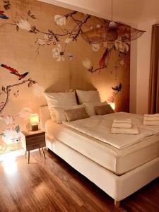 舍讷费尔德BALI HOME Stylische Wohnung mit Terrasse的卧室配有白色的床铺,墙上挂着鲜花
