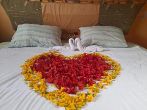 伊瓦拉BUNGALOWS YAHUARCOCHA的床上花朵制成的心