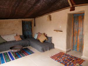 依索安Berber Beldi Camp的客房设有床、沙发和桌子。