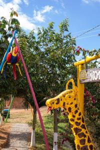 AratocaHOTEL CAMPESTRE ABRAZO DEL ANGEL的玩具长颈鹿和游乐场秋千