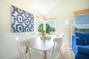 WaterfordMarina Bay Cottages的一间带桌子和蓝色沙发的用餐室