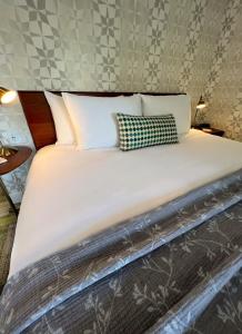 宝云岛鲍恩工匠套房酒店 的一张配有白色床单和枕头的大床