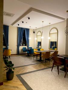 苏博蒂察AVIOR Garni Hotel的一间配备有桌椅的用餐室和蓝色窗帘