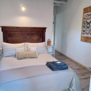 查克拉斯德科里亚El Olivo的卧室配有一张白色大床和木制床头板