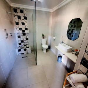 格拉斯科普Paradise View Guesthouse的带淋浴、卫生间和盥洗盆的浴室