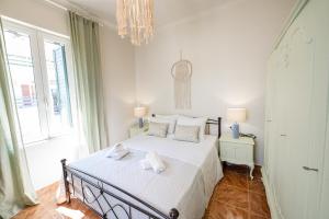 波罗斯Sunny yard apartments的一间卧室配有一张带白色床单和吊灯的床。