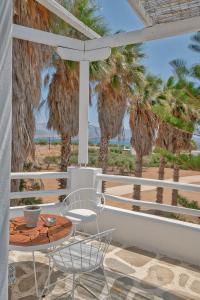 安迪帕罗斯岛Palm Heaven Boutique Apartments的棕榈树阳台的桌椅