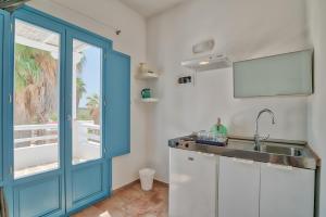 安迪帕罗斯岛Palm Heaven Boutique Apartments的厨房设有水槽和蓝色门