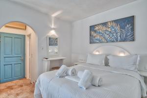 安迪帕罗斯岛Palm Heaven Boutique Apartments的卧室配有白色的床和蓝色的门