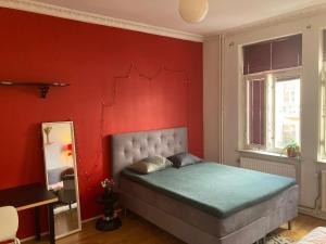 马尔默Rum med eget badrum och stort, delat kök,centralt i Malmö的卧室设有红色墙壁,配有一张床