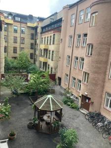 马尔默Rum med eget badrum och stort, delat kök,centralt i Malmö的建筑前方带凉亭的庭院