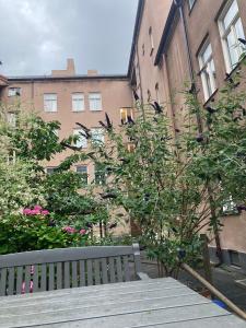 马尔默Rum med eget badrum och stort, delat kök,centralt i Malmö的鲜花盛开的建筑前的公园长凳