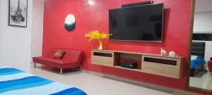 卡塔赫纳Casa con Piscina Privada Playas del Mar的一间客厅,在红色的墙上配有电视