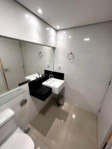 São Gonçalo do Rio AbaixoSG Apart Hotel的一间带水槽、卫生间和镜子的浴室