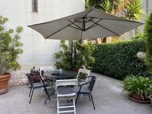 塔兰托Villa Luigi XVI的庭院内桌椅和遮阳伞