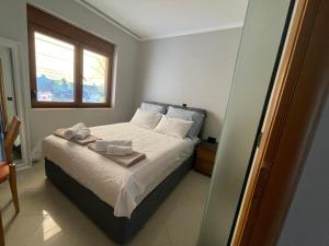 克里皮吉Sunny Seaside Villa-90 m from beach的一间卧室设有一张床、一个窗口和一面镜子