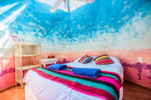 圣佩德罗·德·阿塔卡马Casa Voyage Hostel的一间卧室配有一张壁画床