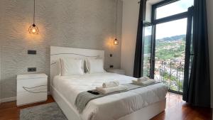 丰沙尔Sea and Sun 4 You - Villa Oliveira的卧室配有白色的床和大窗户