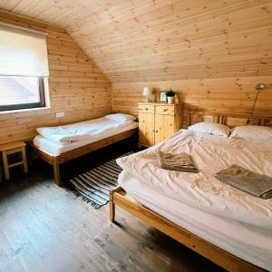 VidrižiKundziņu salas的小木屋内一间卧室,配有两张床