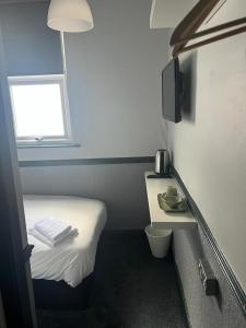 威根Letting Rooms @ Charles Dickens的小房间设有一张小床和一个窗户