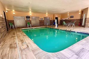 凤凰城Baymont by Wyndham Phoenix North的酒店的大型游泳池配有桌椅