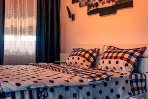 普洛耶什蒂MOZART RESIDENCE PLOIEȘTI Family and Business Apartment的卧室配有带枕头的床铺和窗户。