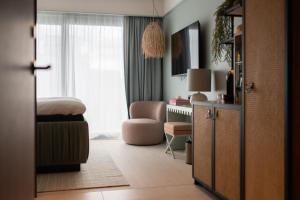 莫斯Hotel Riviera的一间卧室配有一张床、一张桌子和一把椅子