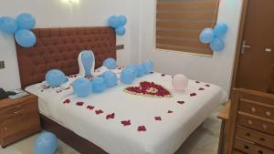 科钦MARINA SUITES AIRPORT HOTEL的一张床上有蛋糕和气球的床